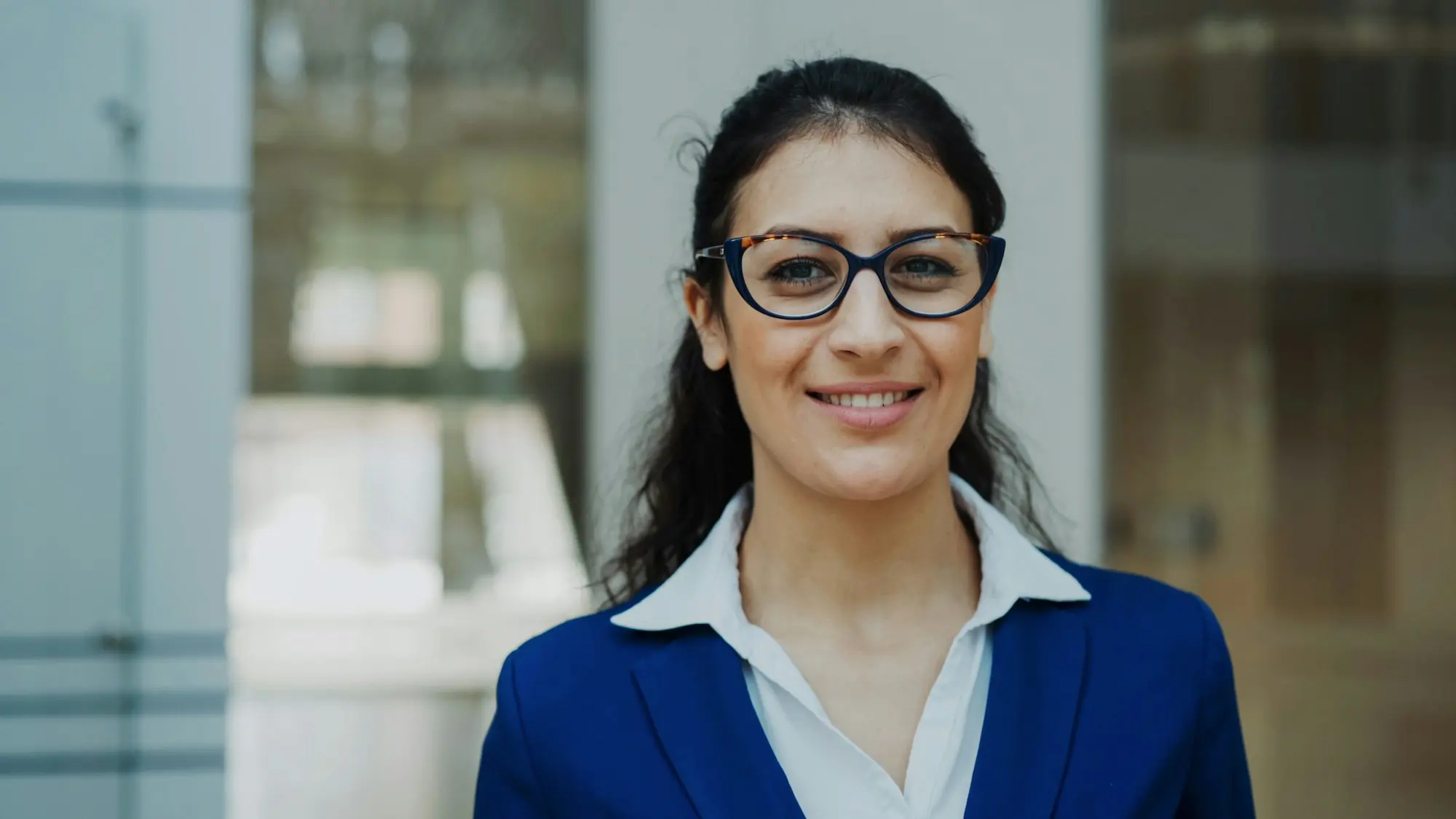 Renata Calder, in a navy suit and dark-rimmed glasses