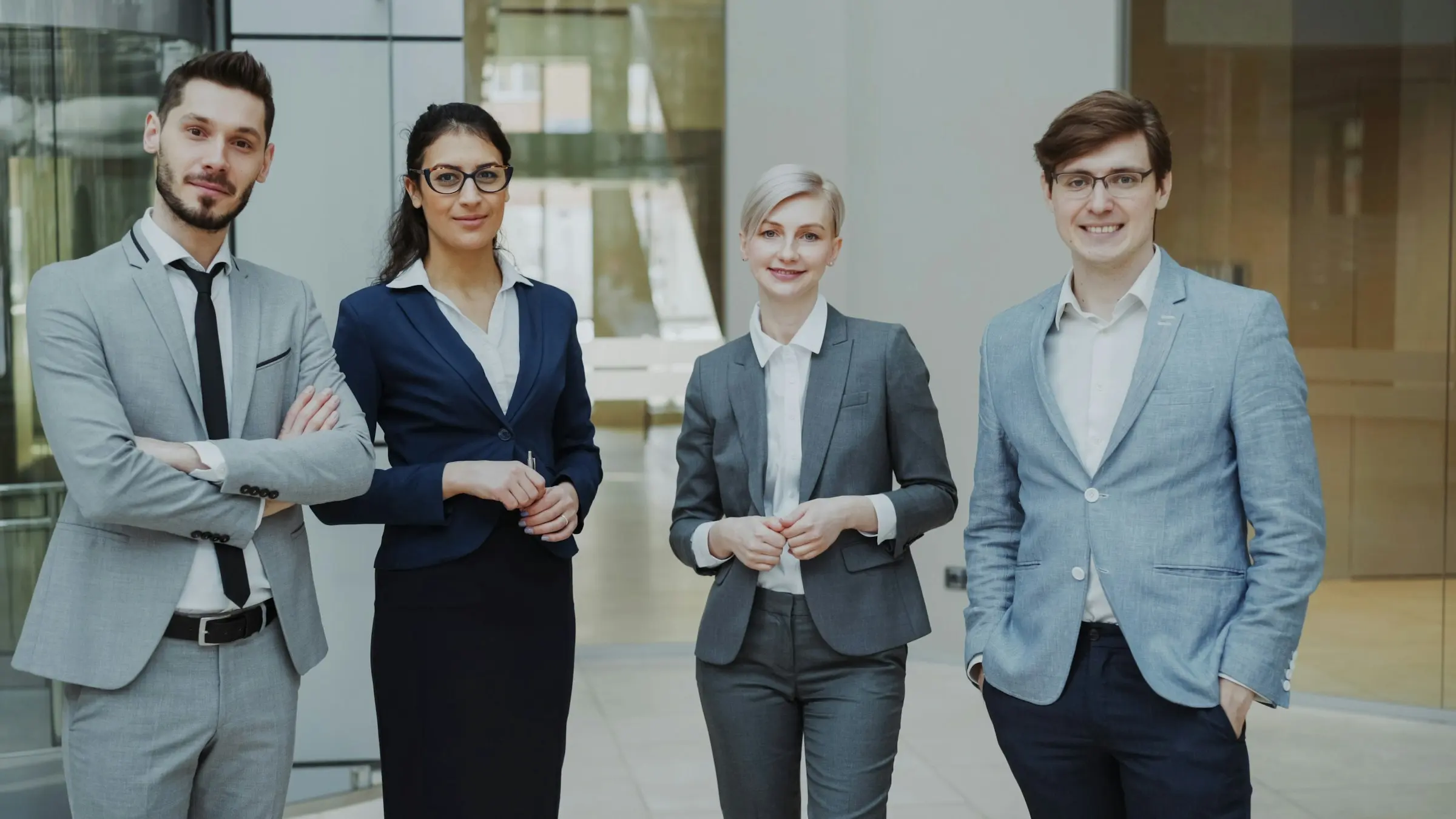 Owen Pell, Renata Calder, Maren Rusk and Theo Marsh standing together in their office lobby