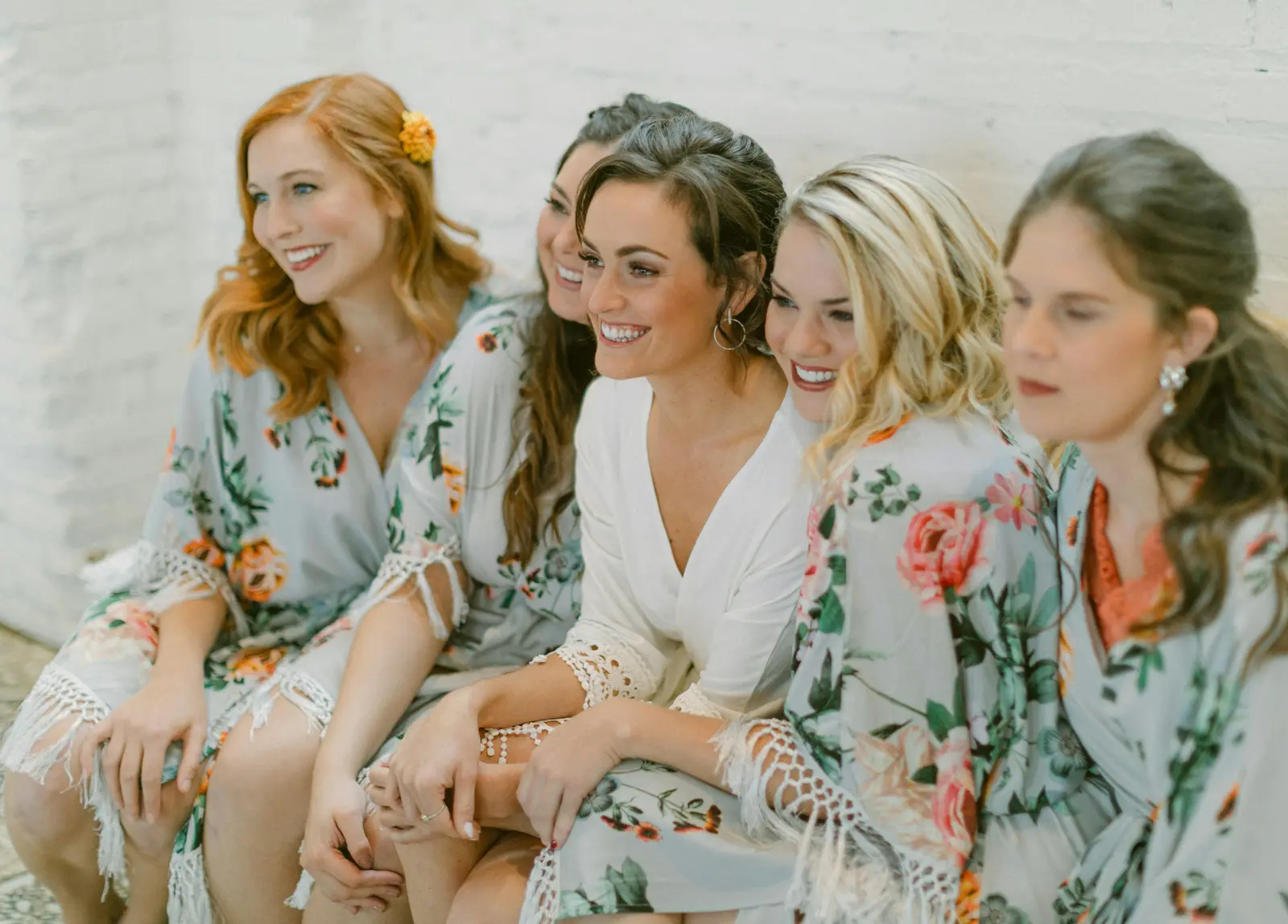Bridesmaids in floral robes laughing together
