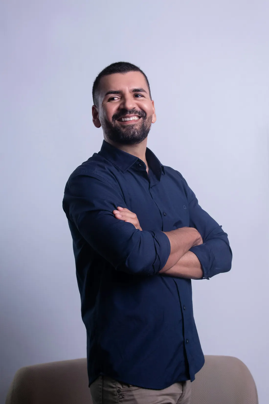 Dr. Tomás Ybarra in a navy shirt, arms crossed, grinning