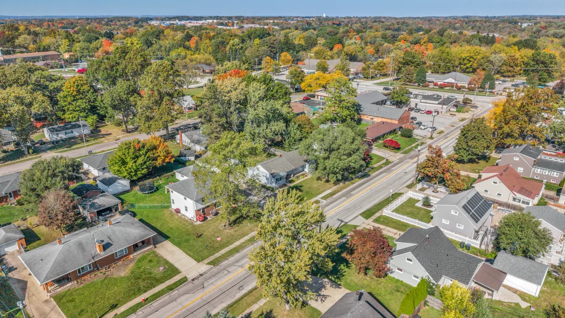 Looking down on a neighborhood of single-story houses and autumn trees